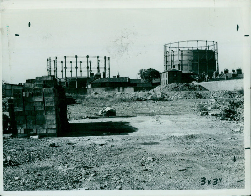 A man in a suit is walking away from the camera with a stack of mail in his hand. - Vintage Photograph