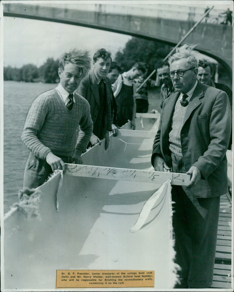 Dr. Q. F. Paechter, junior treasurer of the college boat club, and Mr. Harry Walker examining a revolutionary craft on the raft. - Vintage Photograph