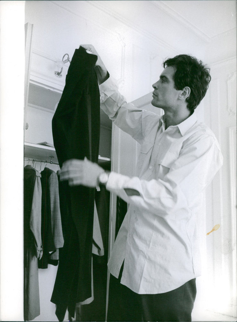 1963

A photo of an American actor, artist, and author George Cadogan Gardner McKay standing and taking dress from shelf. - Vintage Photograph