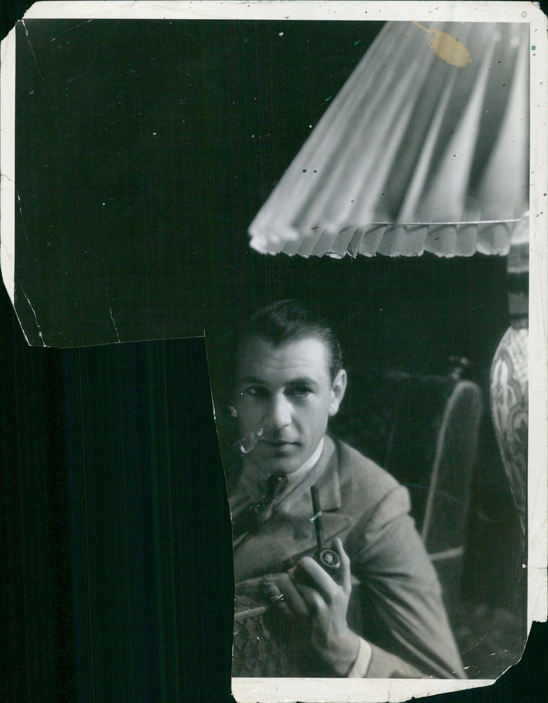 Gary Cooper enjoys a quiet evening at home with his favorite English pipe. - Vintage Photograph