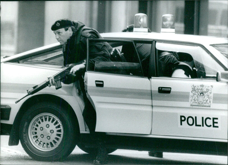 British police officer armed with automatic weapon during security operation - Vintage Photograph