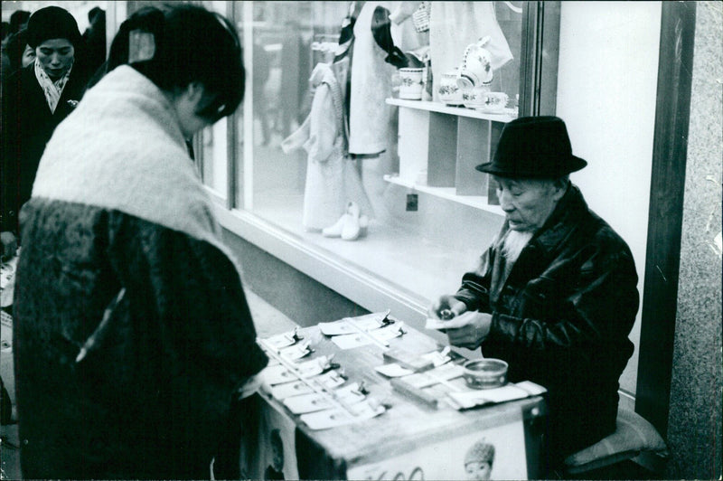 A fortune-teller, replacing the old witches, distributing leaflets about the future. Fortune-tellers are very common figures in Japan. - Vintage Photograph