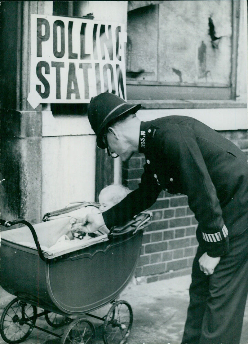 Policeman minding a baby at a London polling station - Vintage Photograph