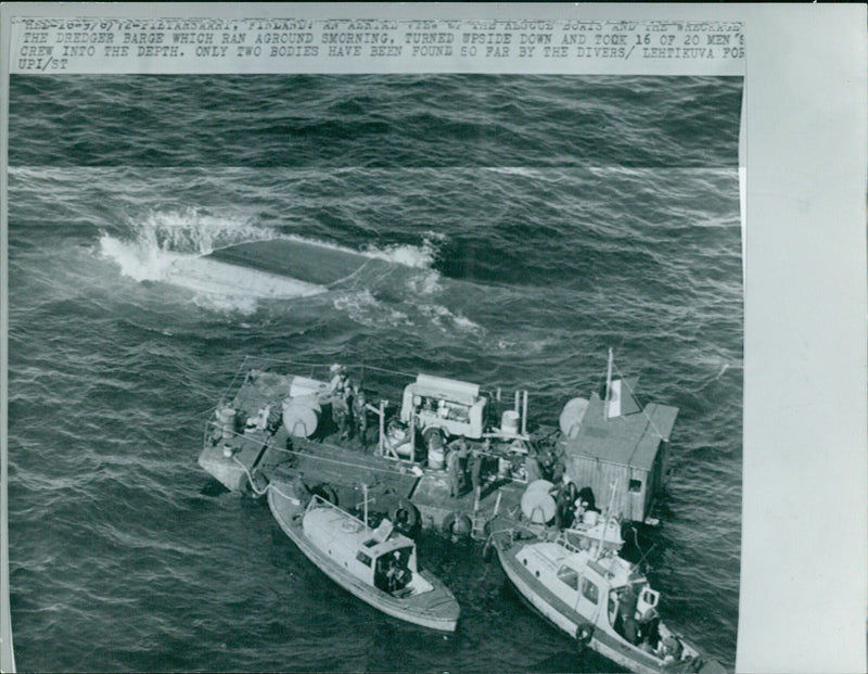 Aerial view of the wreckage of a dredger barge that ran aground and capsized, resulting in the loss of 16 crew members. - Vintage Photograph