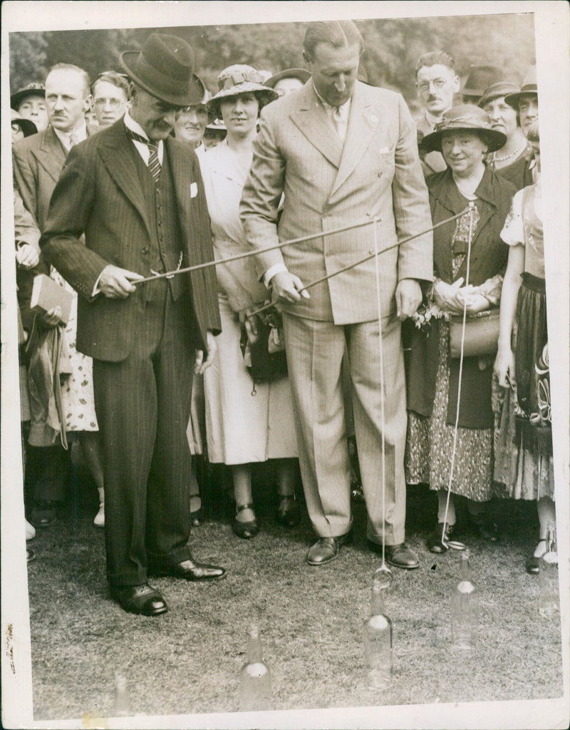 Prime Minister Neville Chamberlain fishing for bottles at a fete - Vintage Photograph