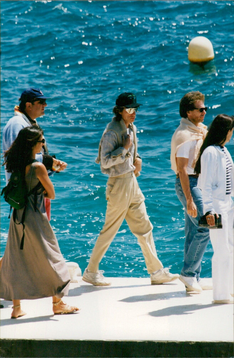 Mick Jagger needs a friendly hand to board the boat taking him to Cannes. - Vintage Photograph