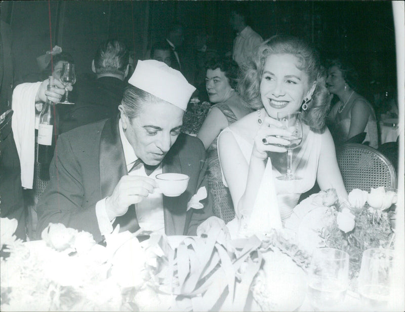 Madame Qrrassis drinking champagne and chatting with Caret Onassis - Vintage Photograph