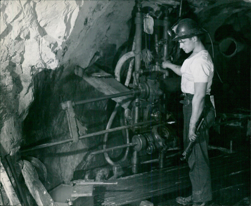 Ex-Pte. Menard, C.I.C. M.G. diamond drill operator pulling rods from a deep hole - Vintage Photograph