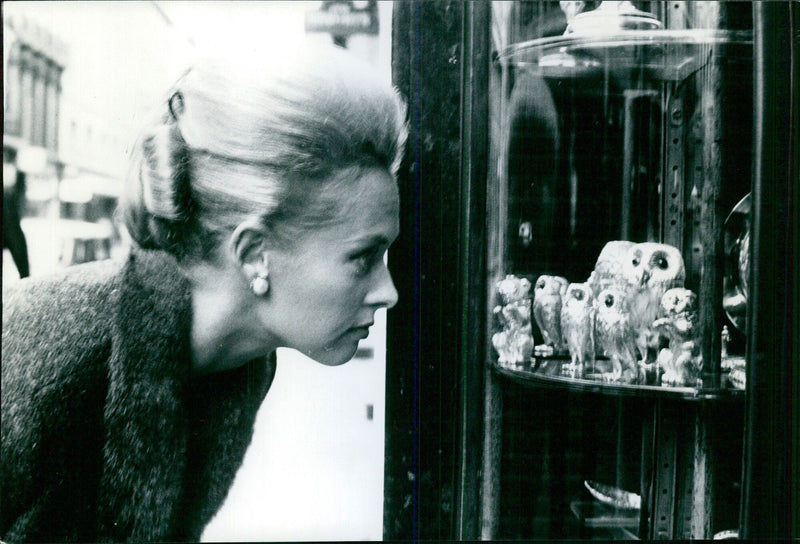 Tippi Hedren admires a collection of silver ornamental owls during a window-shopping expedition in Bond Street. - Vintage Photograph