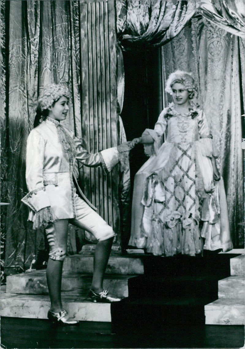 A photo of Princess Elizabeth II and princess Margareth participated in Royal Pantomime; Christmas 1941 top entertain parents and closed friends. - Vintage Photograph