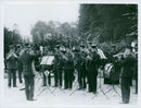 Military band group standing and playing musical instrument, practicing. - Vintage Photograph