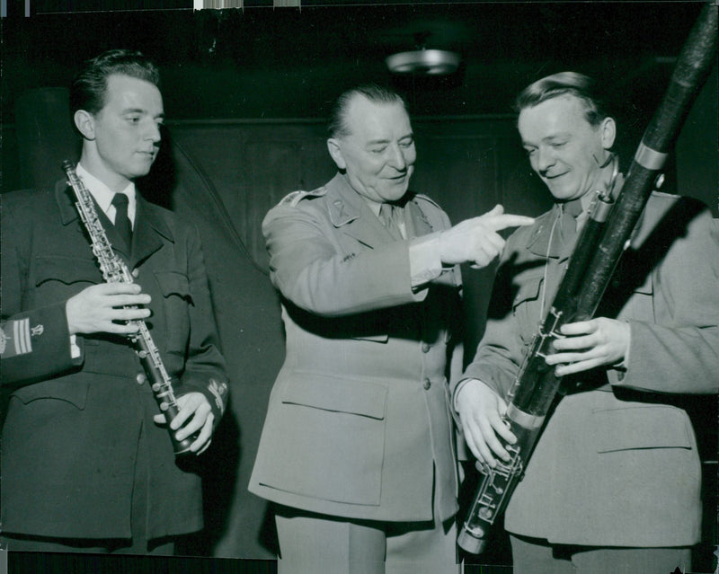 Officers standing and looking the musical instruments. - Vintage Photograph