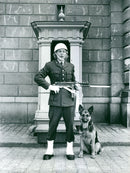 A royal guard standing with a dog and guarding. - Vintage Photograph