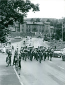 Military band group playing music and parading on the road. - Vintage Photograph
