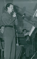Military musical group standing and playing band.

" Music __"
 - 23 April 1949 - Vintage Photograph