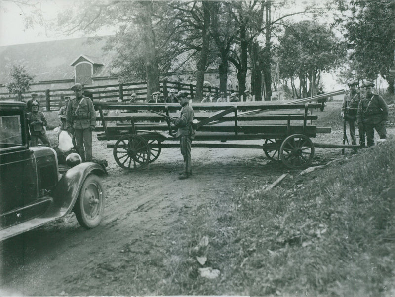 Soldiers gathered in the village, holding gun and standing at check post. - 26 August 1931 - Vintage Photograph