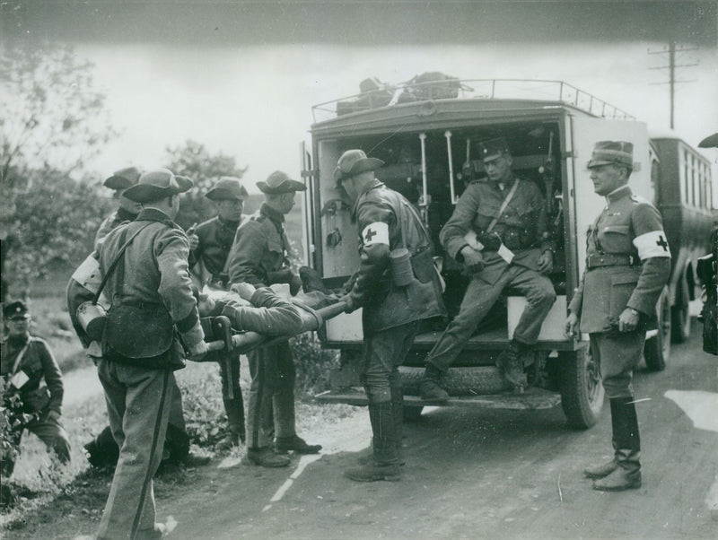 An "injured" soldier is carried aboard an ambulance during the VÃ¤stgÃ¶ta maneuver in 1931 - Vintage Photograph