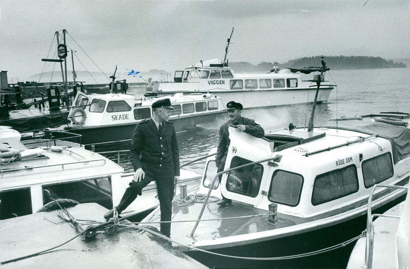 Two boat drivers are talked about in the boathouses. - Vintage Photograph