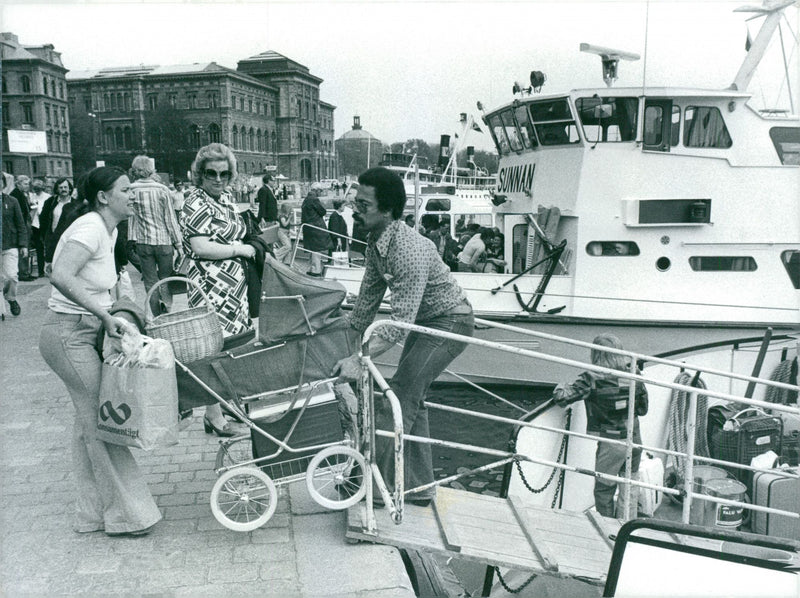 A woman gets help getting the pram on board the archipelago boat to Grinda. - Vintage Photograph