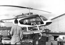 Police helicopter in the air close to the ground with a police officer on the ground - Vintage Photograph