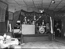 Gert Geller's band are playing music on stage at a restaurant. - Vintage Photograph