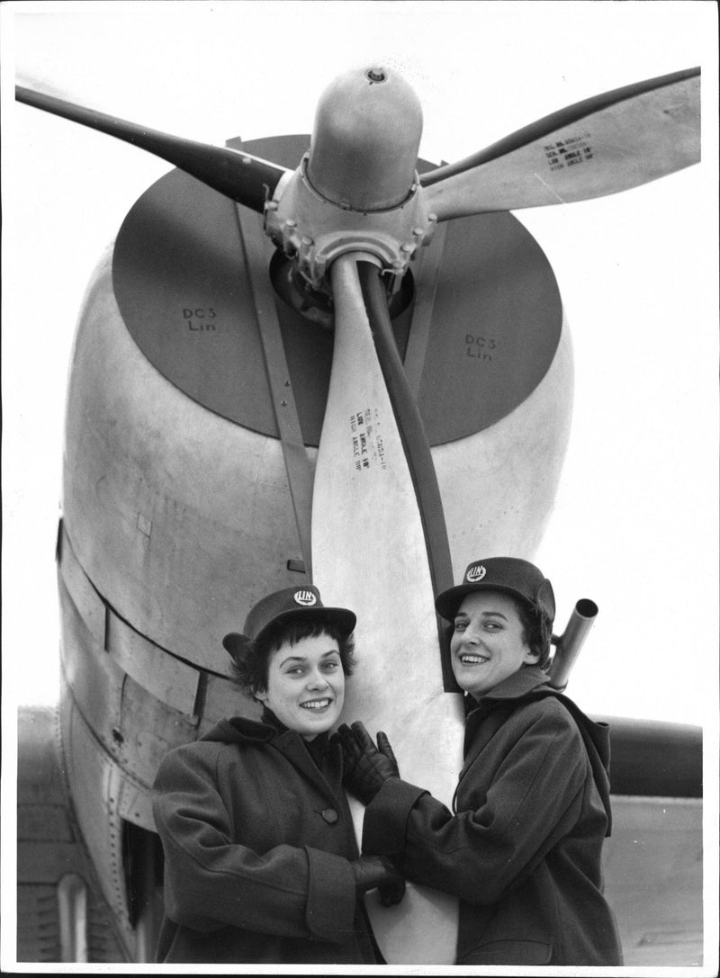 Two of Linjeflyg's first hostesses posing with one of the aircraft's propellers. - Vintage Photograph