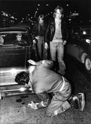 Arne Krook from the Safety Office examines a hot rod on SveavÃ¤gen: - Vintage Photograph