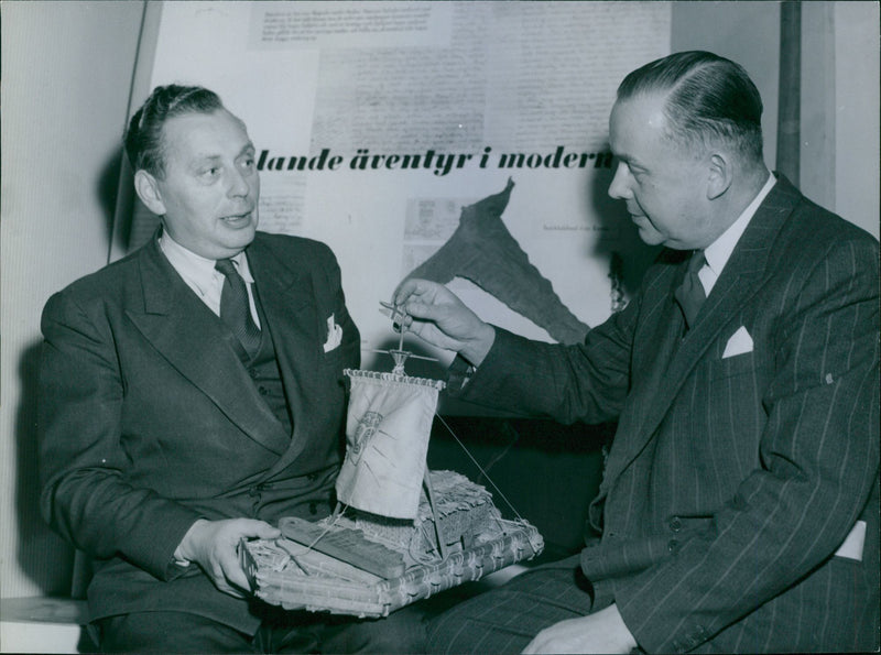 The book week. Booksellers Nils Sandberg and Carl-GÃ¶sta Windell admires a model of Kontiki expedition raft - 18 November 1949 - Vintage Photograph