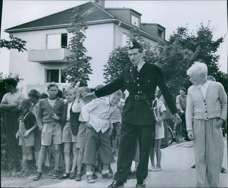 A policeman holds back the curious children after the murder incident in Tureberg - Vintage Photograph