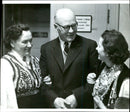 The 39th anniversary of the Estonian Republic is celebrated in the Concert Hall. Minister Hinrich Laratei together with the nationally dressed wives Ella Raudsepp and Anne Roop - Vintage Photograph