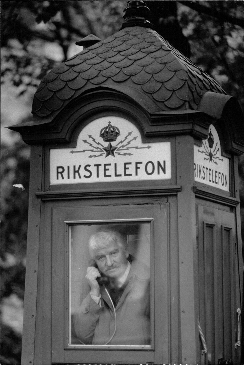 Hasse Alfredsson into a small phone booth of the old model after receiving Telia speaks price - Vintage Photograph