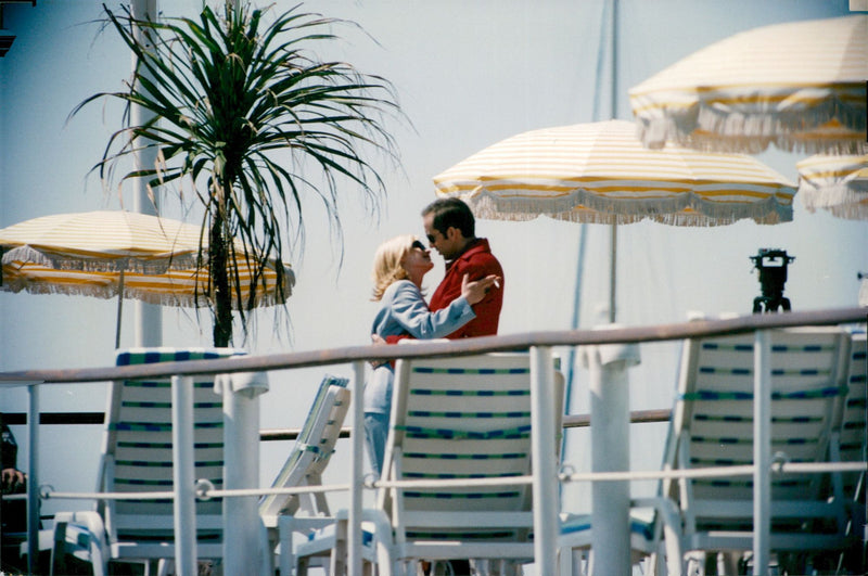 Newlyweds Patricia Arquette and Nicolas Cage cuddling on the beach in Cannes - Vintage Photograph