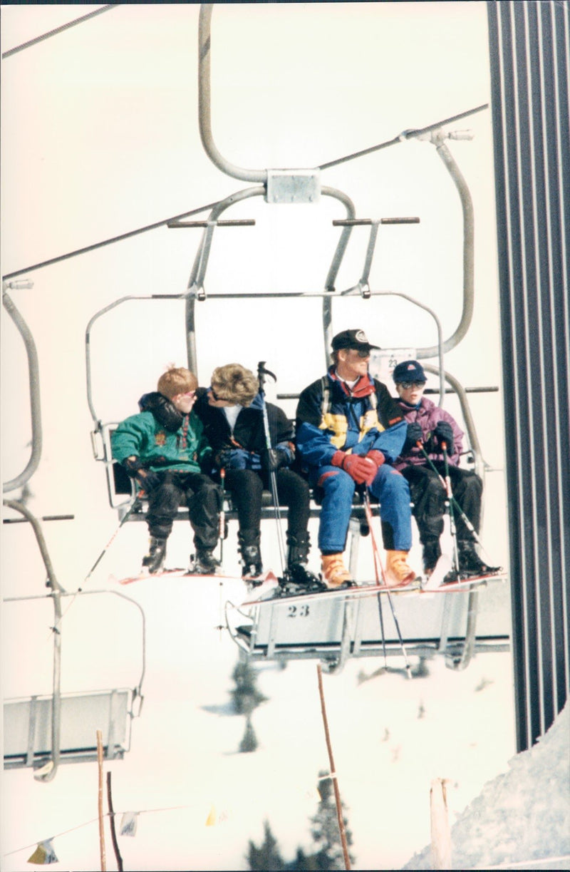 Princess Diana with her sons, Prince William (in purple) and Harry (in green), and ski guide M. Knessi heading up the ski lifts. - Vintage Photograph