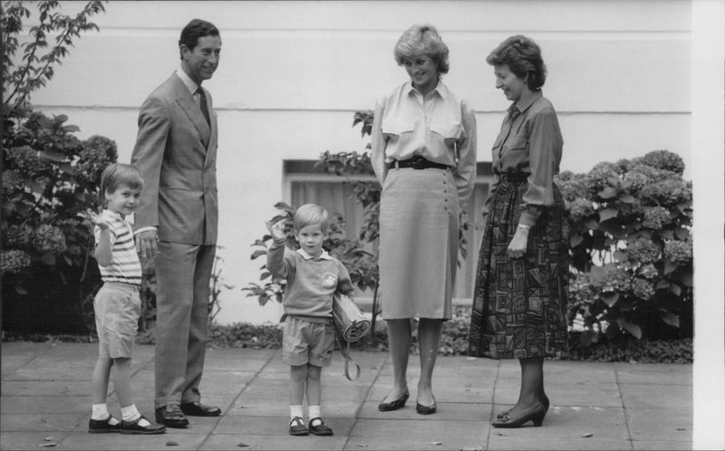 Prince Charles, Prince William and Princess Diana follow Little Prince Harry to the first day at preschool. The preschool teacher receives him. - Vintage Photograph