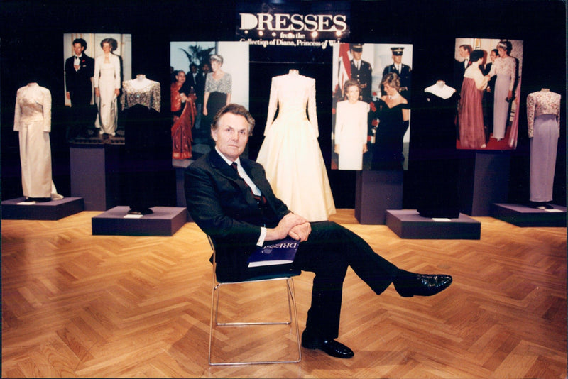 Lord Hindip, Chairman of Chrities's International, in front of some of the dresses that Princess Diana sells. - Vintage Photograph