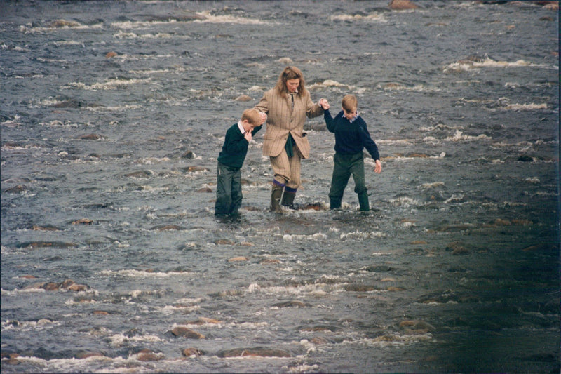 Prince Harry and William wade in the river together with their nanny Tiggy during their vacation in Balmoral, Scotland. - Vintage Photograph
