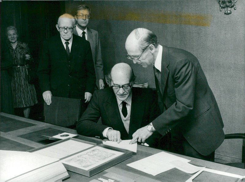 Literature Prize winner Odysseus Elytis assisted by lawyer Bengt Bjerke th signs his books while TV documents the event in audio and video - Vintage Photograph