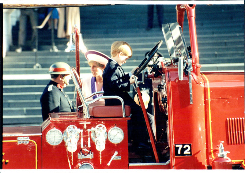 Prince Harry sits in an old-fashioned fire truck with his mother Princess Diana in the background - Vintage Photograph