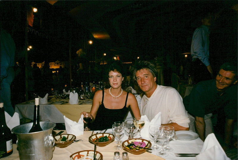 Singer Rod Stewart together with his wife Rachel Hunter during a dinner at the Fashion Cafe. - Vintage Photograph