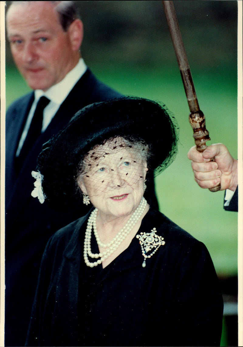 Queen Elizabeth will help keep the umbrella during an event. - Vintage Photograph