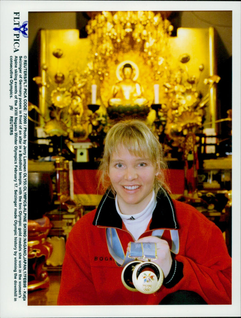 German skier Katja Seizinger poses in front of an altar in a Buddhist temple with his two gold medals from the Winter Olympics 1998 - Vintage Photograph