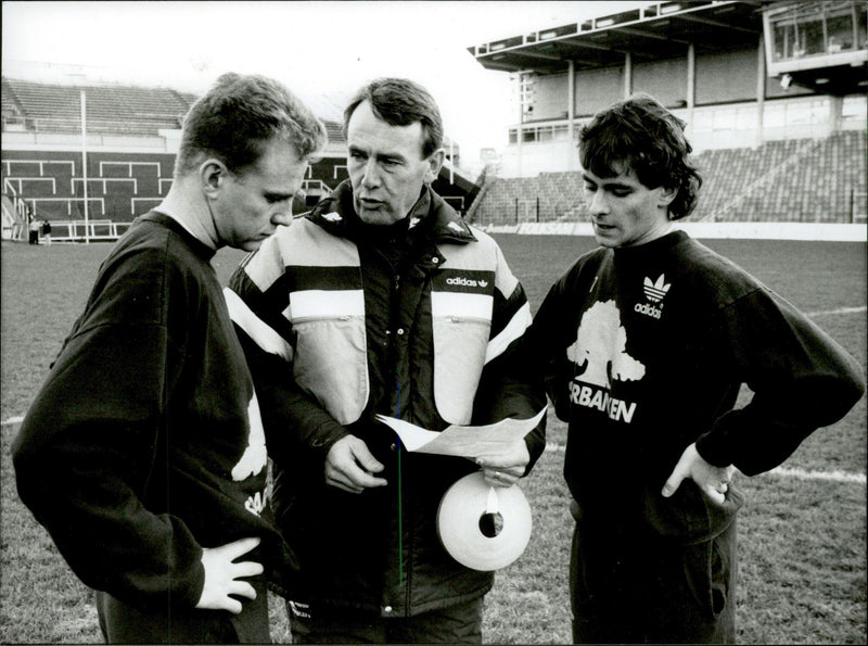 Football coach Nisse Andersson speaks with two of the players. - Vintage Photograph