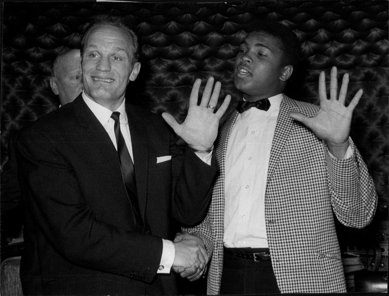 Muhammad Ali shakes hands with Henry Cooper during a lunch they had in London. - Vintage Photograph