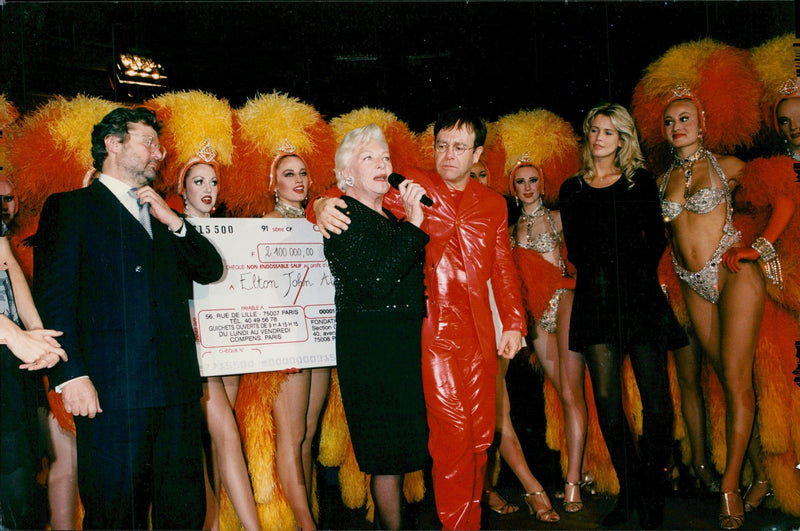Line Renaud awarded a check by Elton John at the Moulin Rouge charity hosted by the Cartier Foundation and Elton John AIDS Foundation - Vintage Photograph