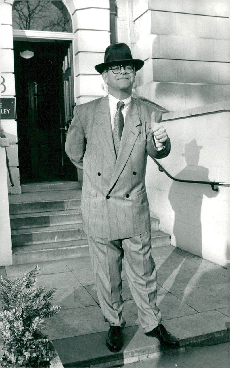 The musician Elton John makes his thumb up against the camera. - Vintage Photograph