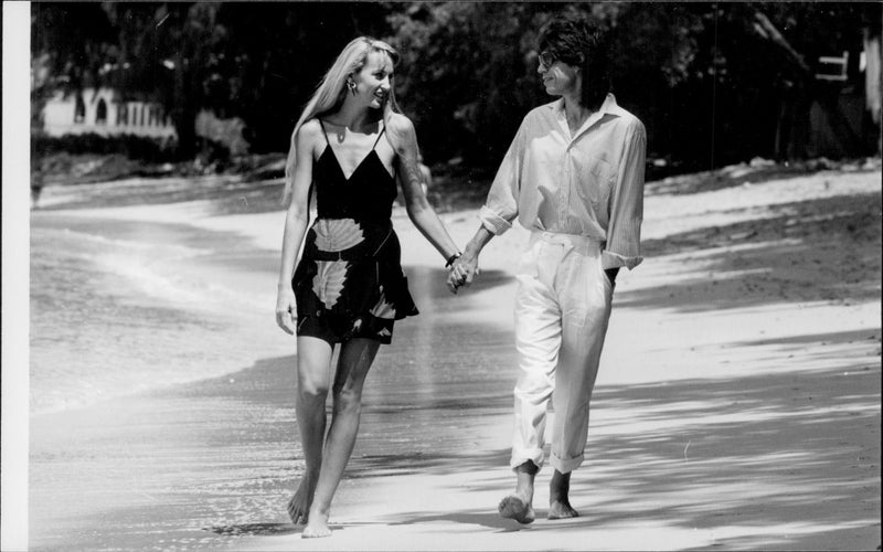 Jerry Hall och Mick Jagger njuter av sol och strand på Barbados. - Vintage Photograph