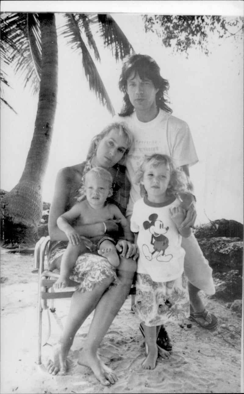 Mick Jagger and the model Jerry Hall with their children Elizabeth Scarlet and James Leroy on the beach at Fryers Well - Vintage Photograph