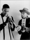 Denzel Washington playing a musical instrument standing with Spike Lee in a scene of 1990's film "Mo' Better Blues" - Vintage Photograph