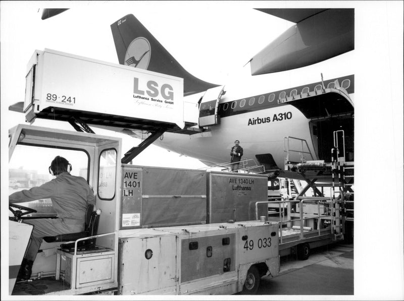 The cans with passenger meals are loaded on a Lufthansa Airbus A310. - Vintage Photograph