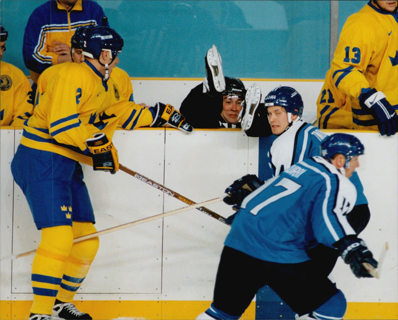 Judge Kerry Hilton Fraser jumps on the rink to take shelter during the ice hockey match Sweden - Finland during the Winter Olympics in Nagano 1998 - Vintage Photograph